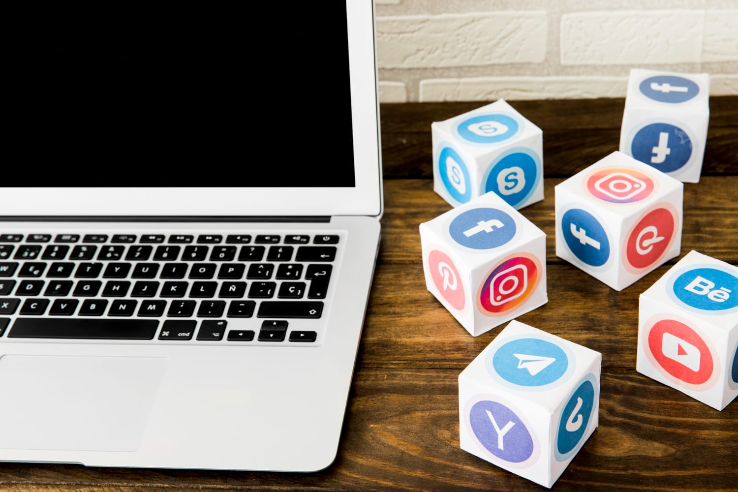 Laptop on a desk with social media icons